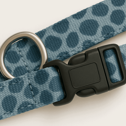 Close-up of PawTaaka blue leopard print dog collar showing durable nylon webbing, secure buckle, and metal D-ring.