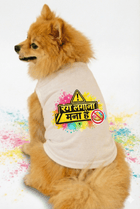 Small dog wearing a white shirt with colorful text and symbols on a white background