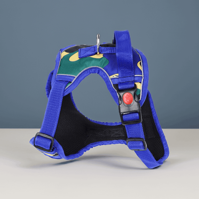 Camo Burst Reflective Dog Vest Harness – Blue Jungle by PawTaaka displayed on tabletop, highlighting its vibrant camo design and sturdy build.